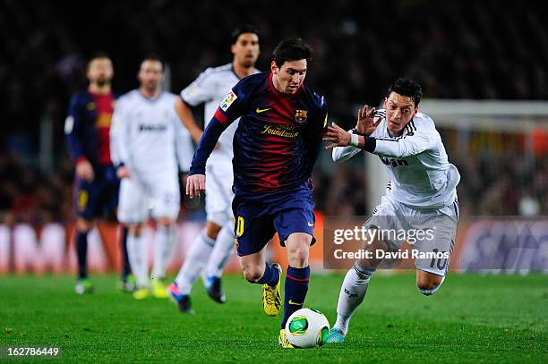Lionel Messi of FC Barcelona duels for the ball with Mesut Ozil of Real Madrid CF during the Copa del Rey Semi Final second leg between FC Barcelona...