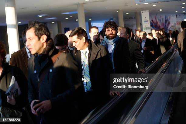 Visitors travel along a moving walkway as they exit the Mobile World Congress in Barcelona, Spain, on Tuesday, Feb. 26, 2013. The Mobile World...