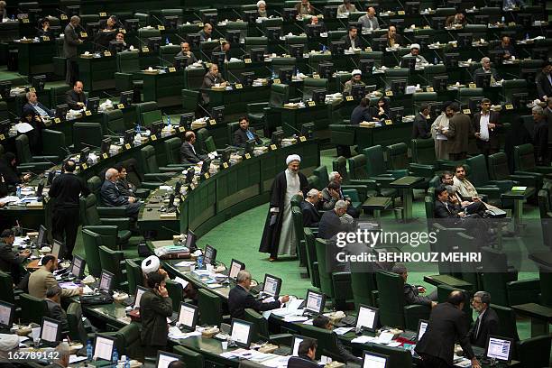 Iranian Members of Parliament attend a parliament session to discuss the annual budget bill which is being presented by the government in Tehran on...