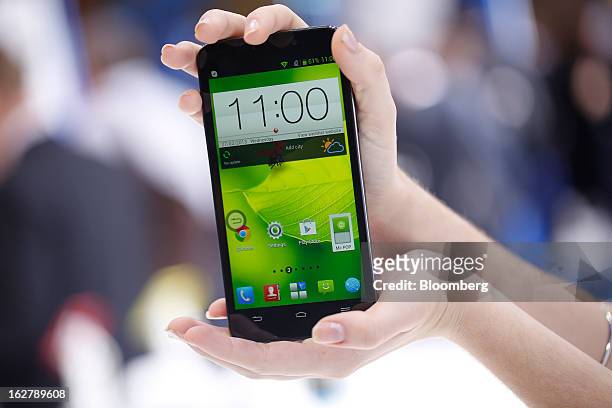 An employee holds a ZTE Corp. Grand Memo smartphone for a photograph at the Mobile World Congress in Barcelona, Spain, on Wednesday, Feb. 27, 2013....