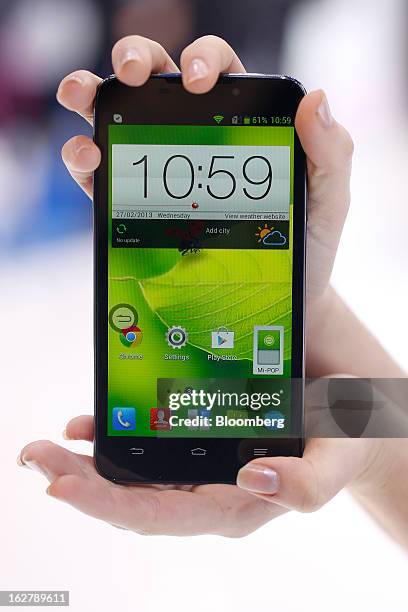 An employee holds a ZTE Corp. Grand Memo smartphone for a photograph at the Mobile World Congress in Barcelona, Spain, on Wednesday, Feb. 27, 2013....