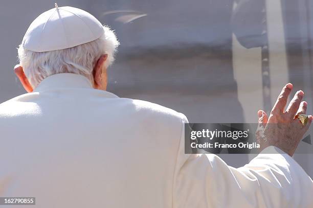 Pope Benedict XVI waves to the faithful as he leaves St Peter's Square at the end of his final general audience on February 27, 2013 in Vatican City,...