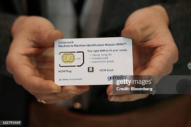 An employee displays a Gemalto NV M2M quad sim card at the Mobile World Congress in Barcelona, Spain, on Wednesday, Feb. 27, 2013. The Mobile World...