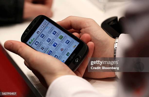 Visitor holds a Stylistic S01 smartphone in the Fujitsu Ltd. Pavilion at the Mobile World Congress in Barcelona, Spain, on Wednesday, Feb. 27, 2013....