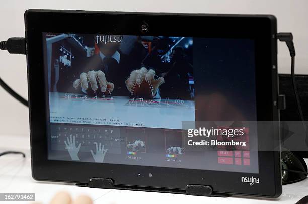 An employee demonstrates the gesture keyboard facility on a Stylistic Q572 tablet in the Fujitsu Ltd. Pavilion at the Mobile World Congress in...