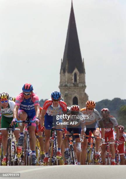 The cyclists of the 86th Tour de France pass nearby a church during the third stage of the 'Grande Boucle', between Nantes and Laval, western France,...