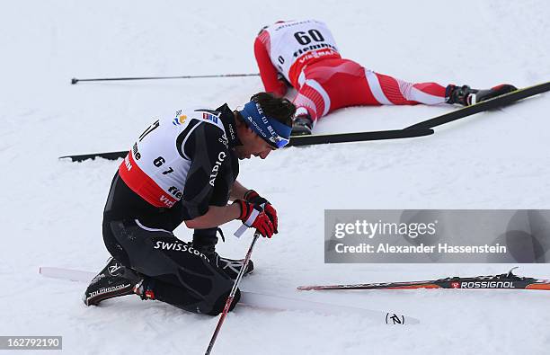 Curdin Perl of Switzerland and Sebastian Gaurek of Poland react after finishing during the Men's Cross Country Individual 15km at the FIS Nordic...