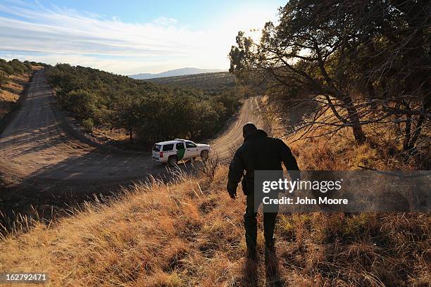 Border Patrol agent walks to his vehicle near the U.S. Border with Mexico on February 26, 2013 near Sonoita, Arizona. The Federal government has...