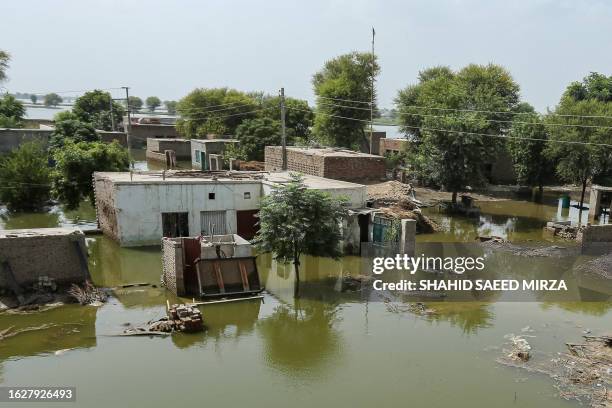 Houses are pictured half submerged in flood waters at Burewala, a town of southern Punjab province of on August 27, 2023.