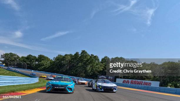 Denny Hamlin, driver of the Mavis Tires & Brakes Toyota, and William Byron, driver of the Valvoline Chevrolet, lead the field on a pace lap prior to...