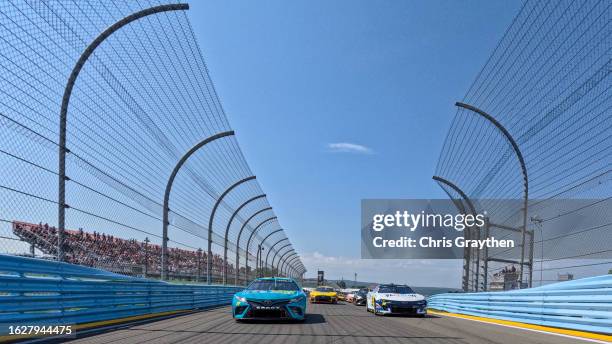 Denny Hamlin, driver of the Mavis Tires & Brakes Toyota, and William Byron, driver of the Valvoline Chevrolet, lead the field on a pace lap prior to...