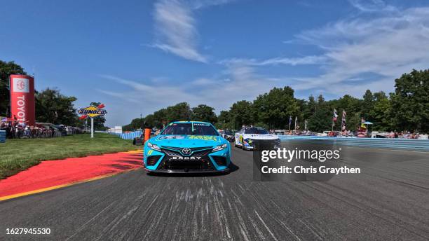 Denny Hamlin, driver of the Mavis Tires & Brakes Toyota, and William Byron, driver of the Valvoline Chevrolet, lead the field on a pace lap prior to...