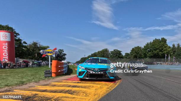 Denny Hamlin, driver of the Mavis Tires & Brakes Toyota, and William Byron, driver of the Valvoline Chevrolet, lead the field on a pace lap prior to...