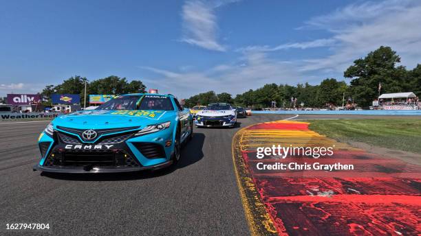 Denny Hamlin, driver of the Mavis Tires & Brakes Toyota, and William Byron, driver of the Valvoline Chevrolet, lead the field on a pace lap prior to...