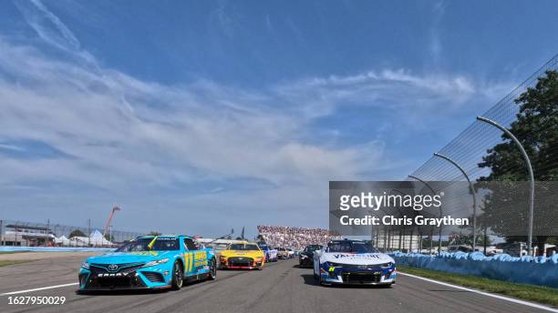 Denny Hamlin, driver of the Mavis Tires & Brakes Toyota, and William Byron, driver of the Valvoline Chevrolet, lead the field on a pace lap prior to...