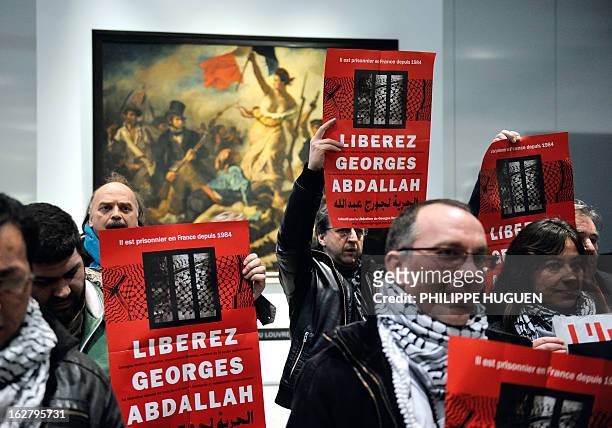 French communist militants hold placards reading "Free Georges Abdallah" on February 27, 2013 as they are gathered in front of French painter Eugene...
