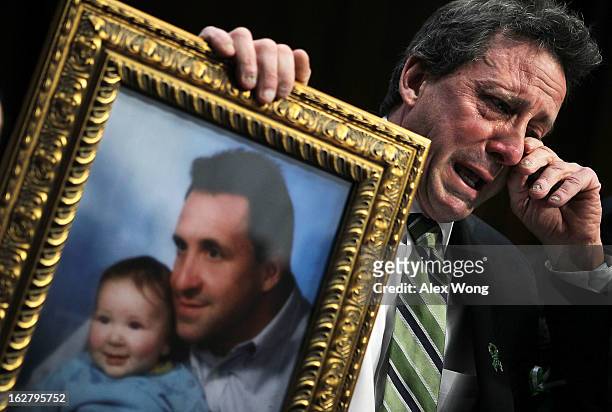 Neil Heslin, father of six-year-old Sandy Hook Elementary School shooting victim Jesse Lewis, wipes tears as he testifies during a hearing before the...