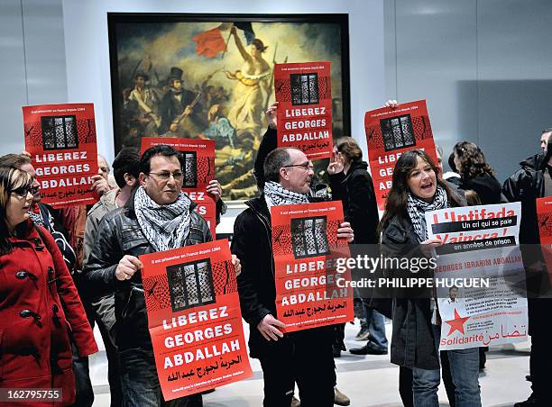 French communist militants hold placards reading "Free Georges Abdallah" on February 27, 2013 as they are gathered in front of French painter Eugene...