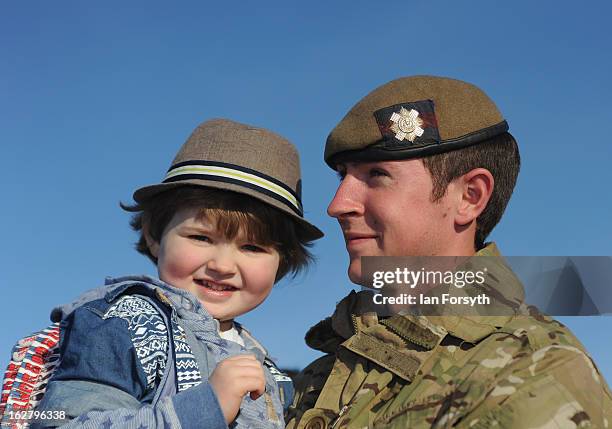 Lance Sergeant Ed Ennis holds his son Finlay as soldiers from Headquarters Company 1st Battalion The Scots Guards return to their base at Bourlon...