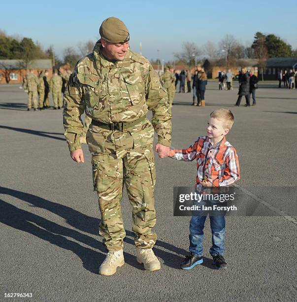 Sergeant Michael Thompson holds the hand of his son, Charlie as soldiers from Headquarters Company 1st Battalion The Scots Guards return to their...