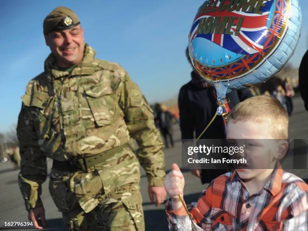 Sergeant Michael Thompson watches as his son, Charlie celebrates his return as soldiers from Headquarters Company 1st Battalion The Scots Guards...