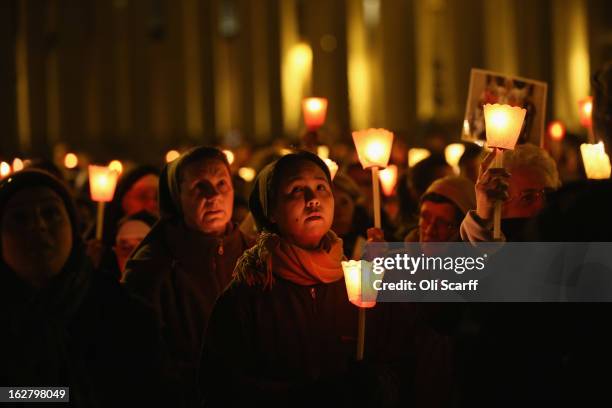 Pilgrims and clergy members hold a candle-lit vigil in Saint Peter's Square, facing Pope Benedict XVI's private apartment, after his final weekly...