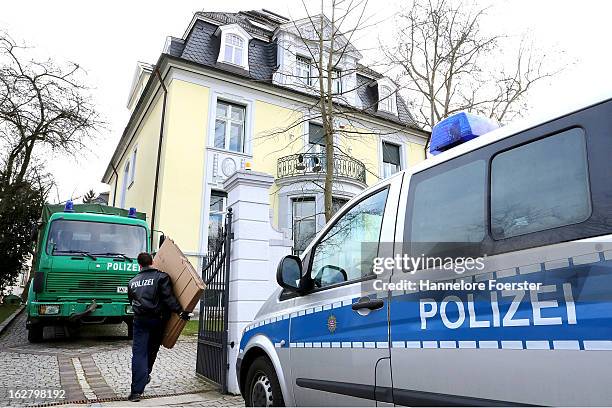 Policeman carries boxes to the headquarters of the S&K investment group the day after police raided the company's offices on February 20, 2013 in...