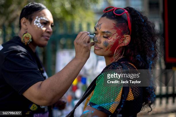 Woman has her face painted on families and children's day at Notting Hill Carnival on August 27, 2023 in London, England. The annual Caribbean...