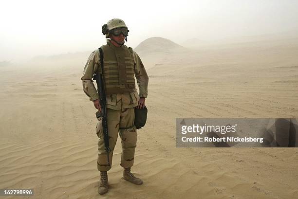 Marine from the 1st Marine Division stands in a 45 mph sandstorm February 3, 2003 during exercises 15-20 miles south of the Iraqi border in Udairi...