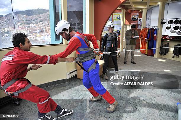 Israeli tourist Liron Sitrek is trained before practicing "rap-jumping" at a hotel in La Paz on February 27, 2013. Sitrek went down some 50 meters...