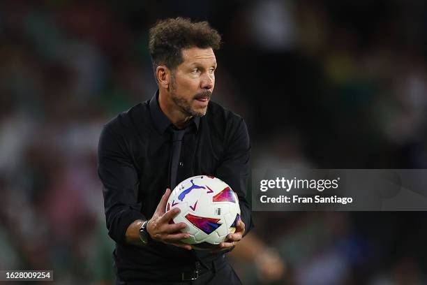 Diego Simeone, Head Coach of Atletico Madrid, holds the ball during the LaLiga EA Sports match between Real Betis and Atletico Madrid at Estadio...