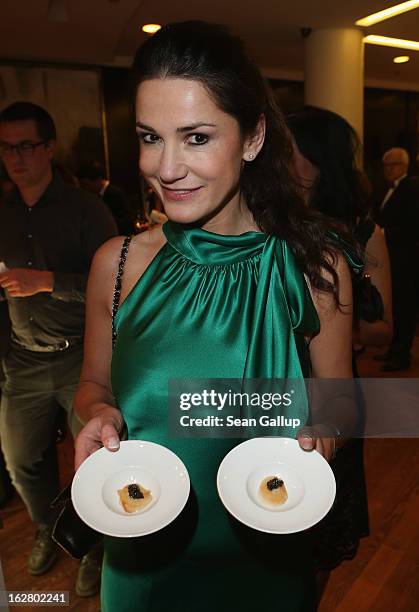 Mariella Ahrens holds plates of caviar as she attends the grand opening of the Waldorf Astoria Berlin hotel on February 27, 2013 in Berlin, Germany.