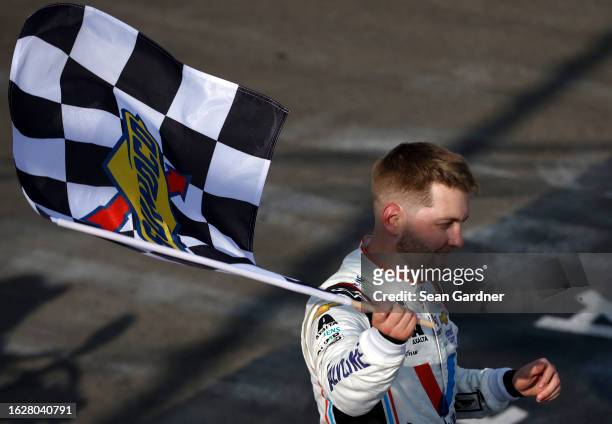 William Byron, driver of the Valvoline Chevrolet, celebrates with the checkered flag after winning the NASCAR Cup Series Go Bowling at The Glen at...