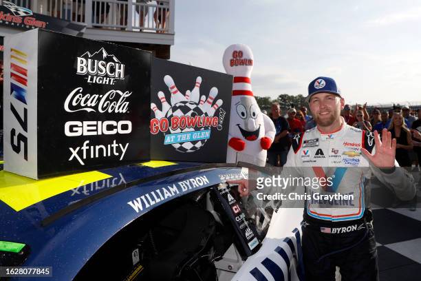 William Byron, driver of the Valvoline Chevrolet, poses with the winner sticker on his car in victory lane after winning the NASCAR Cup Series Go...