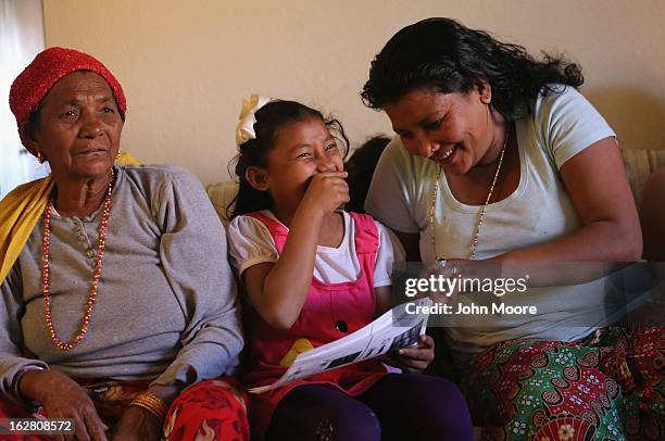 Bhutanese refugees examine a home excericse regimen during a home visit by International Rescue Committee , members on February 27, 2013 in Tucson,...