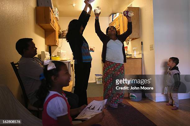 Bhutanese refugee Nar Darjee practices a home excercise regimen given by International Rescue Committee , members during a home visit on February 27,...