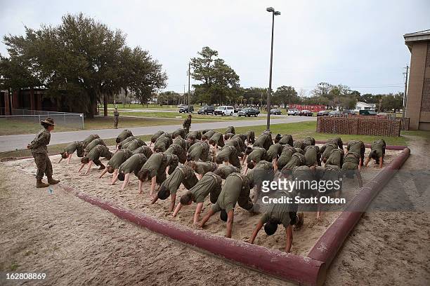 Drill Instructor SSgt. Jennifer Garza of Kerrville, Texas disciplines her Marine recruits with some unscheduled physical training in the sand pit...