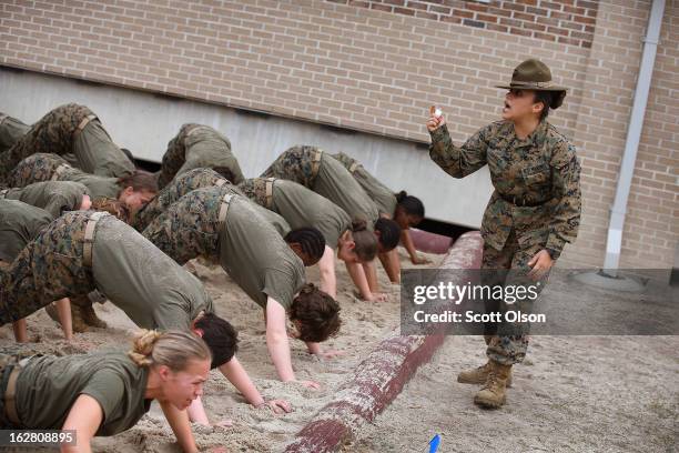 Drill Instructor SSgt. Jennifer Garza of Kerrville, Texas disciplines her Marine recruits with some unscheduled physical training in the sand pit...