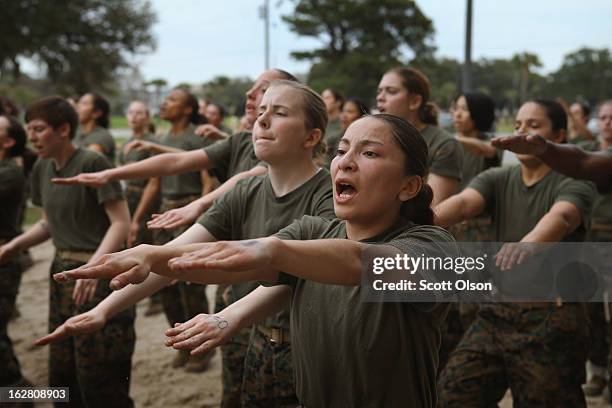 Female Marine recruits are disciplined with some unscheduled physical training in the sand pit outside their barracks during boot camp February 27,...