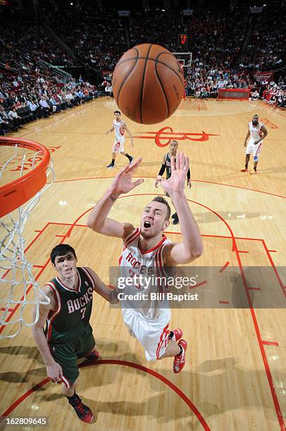 Donatas Motiejunas of the Houston Rockets shoots against Ersan Ilyasova of the Milwaukee Bucks on February 27, 2013 at the Toyota Center in Houston,...