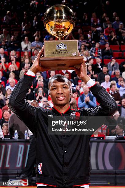 Damian Lillard of the Portland Trail Blazers receives his trophy for winning the NBA All-Star 2013 Taco Bell Skills Challenge before a game against...