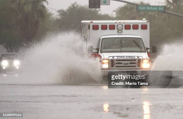 An ambulance drives through a flooded street as Tropical Storm Hilary approaches on August 20, 2023 in Palm Springs, California. Southern California...