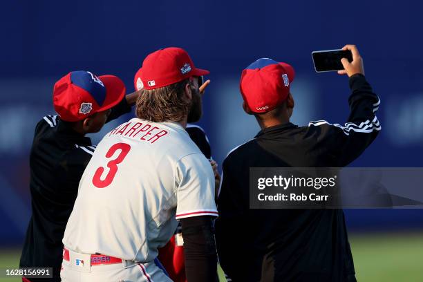 Bryce Harper of the Philadelphia Phillies takes a selfie with the Little League team from Cub before the start of the 2023 Little League Classic...