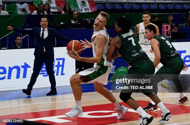 Jorge Gutierrez of Mexico guards against Vaidas Kariniauskas of Lithuania while Mexico's head coach Omart Quintero reacts during their FIBA...