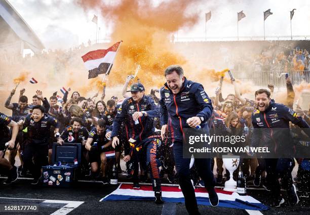 Red Bull Racing's Dutch driver Max Verstappen and Red Bull Racing's British team principal Christian Horner celebrate with the members of the Red...