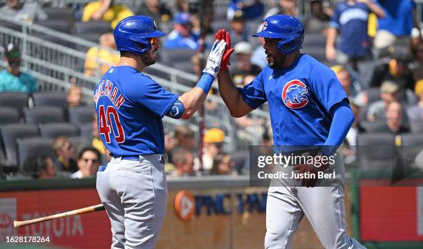 Jeimer Candelario of the Chicago Cubs high fives with Mike Tauchman after hitting a two run home run in the fourth inning during the game against the...