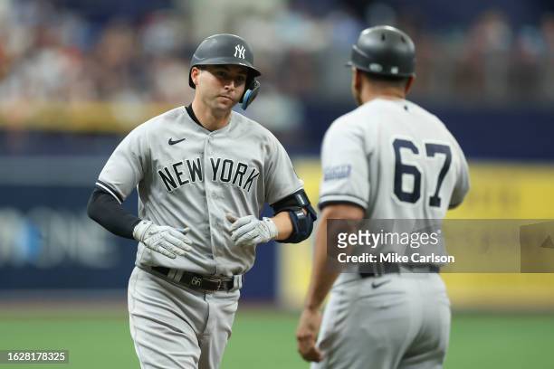 Kyle Higashioka of the New York Yankees high-fives third base coach Luis Rojas after hitting a solo home run in the third inning during the game...