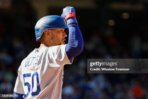 Mookie Betts of the Los Angeles Dodgers celebrates towards his bullpen after his RBI single against the Boston Red Sox during the eighth inning at...