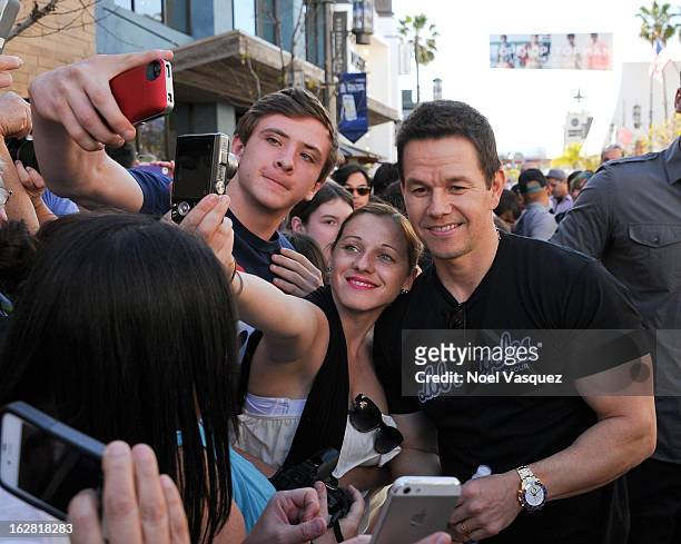 Mark Wahlberg poses with fans at Extra at The Grove on February 27, 2013 in Los Angeles, California.