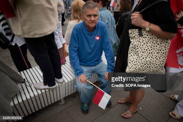 Man holds a Polish flag as he listens to Donald Tusk speak during his campaign rally in Sopot. Civic Platform leader Donald Tusk visited his home...
